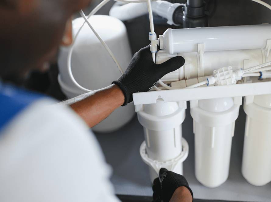 Technician servicing a reverse osmosis water filtration system, showcasing the maintenance process for reliable desalinated water with ECHOTec Watermakers.