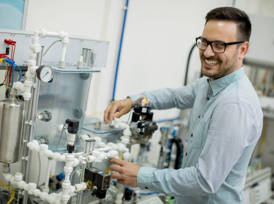 Young man working a home desalination machine using reverse osmosis to create drinking water.