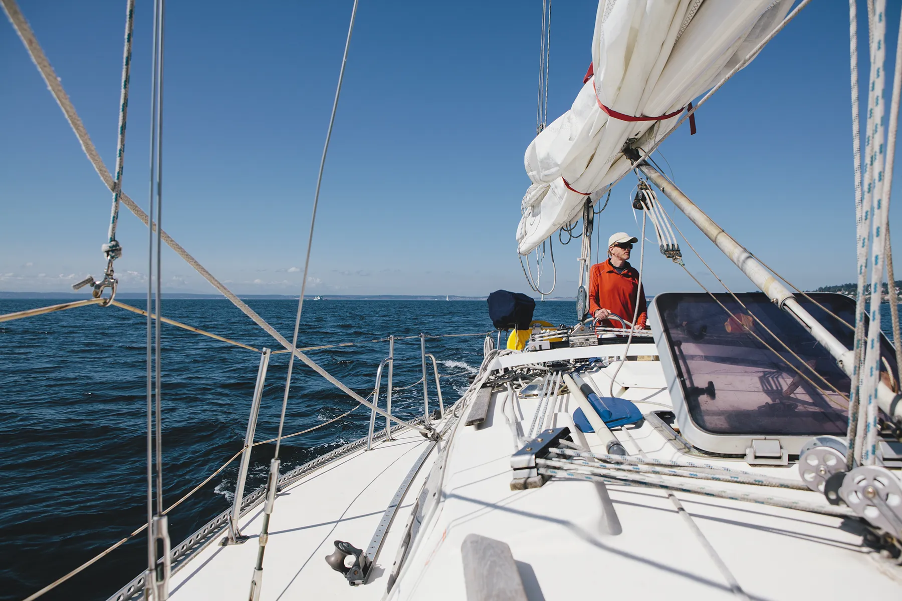 Middle aged man steering sailboat on Puget Sound, Washington, USA Middle aged man steering sailboat on Puget Sound, Washington, USA