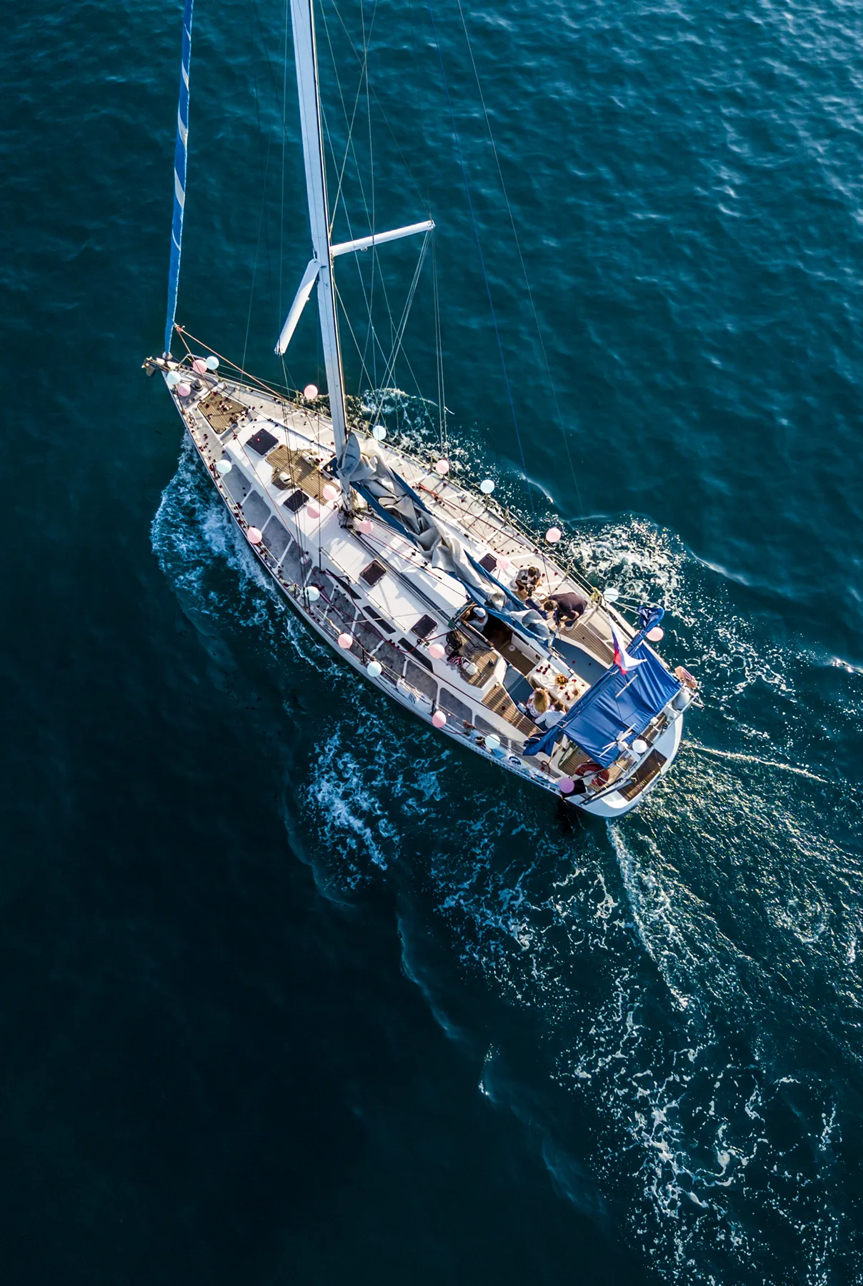overhead top aerial view of luxury sail boat in the crystal clear blue sea water lagoon