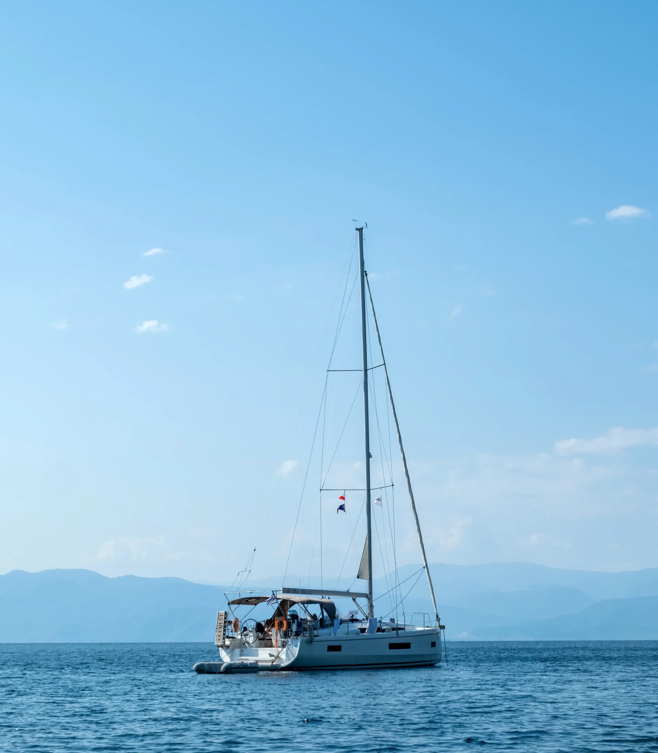 Summer vacation destination Greece. Luxury white yacht moored in open vast Aegean sea water.