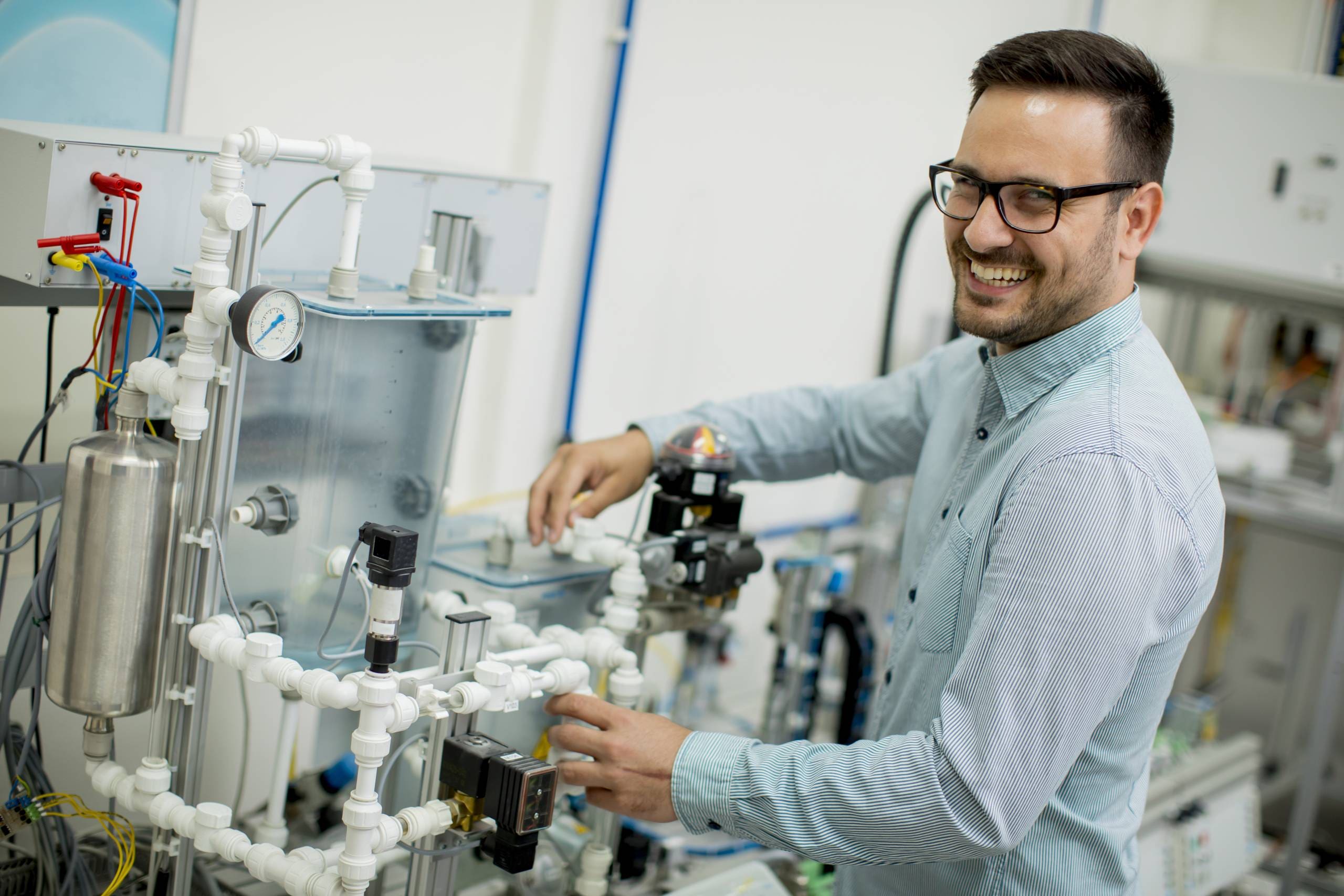 Young man working a home desalination machine using reverse osmosis to create drinking water.